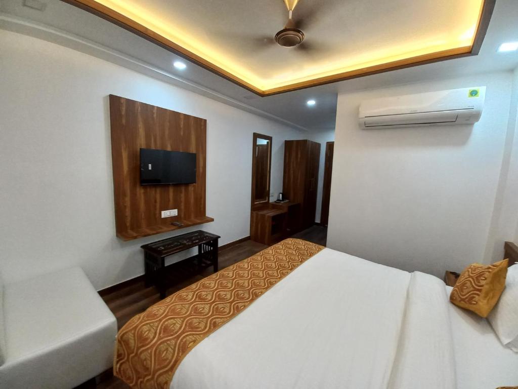 阿格拉Hotel The Rich Grand Agra的一间酒店客房,配有一张床和一台电视