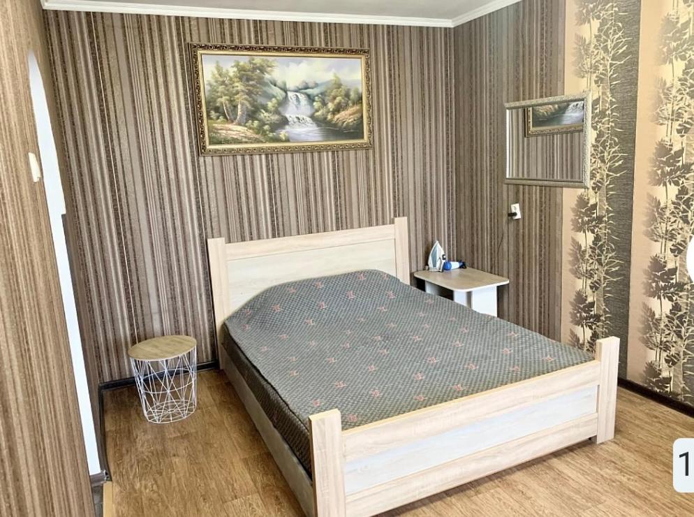 切尔尼戈夫Апартаменты в самом Центре прПобеды 90的卧室配有一张床,墙上挂有绘画作品