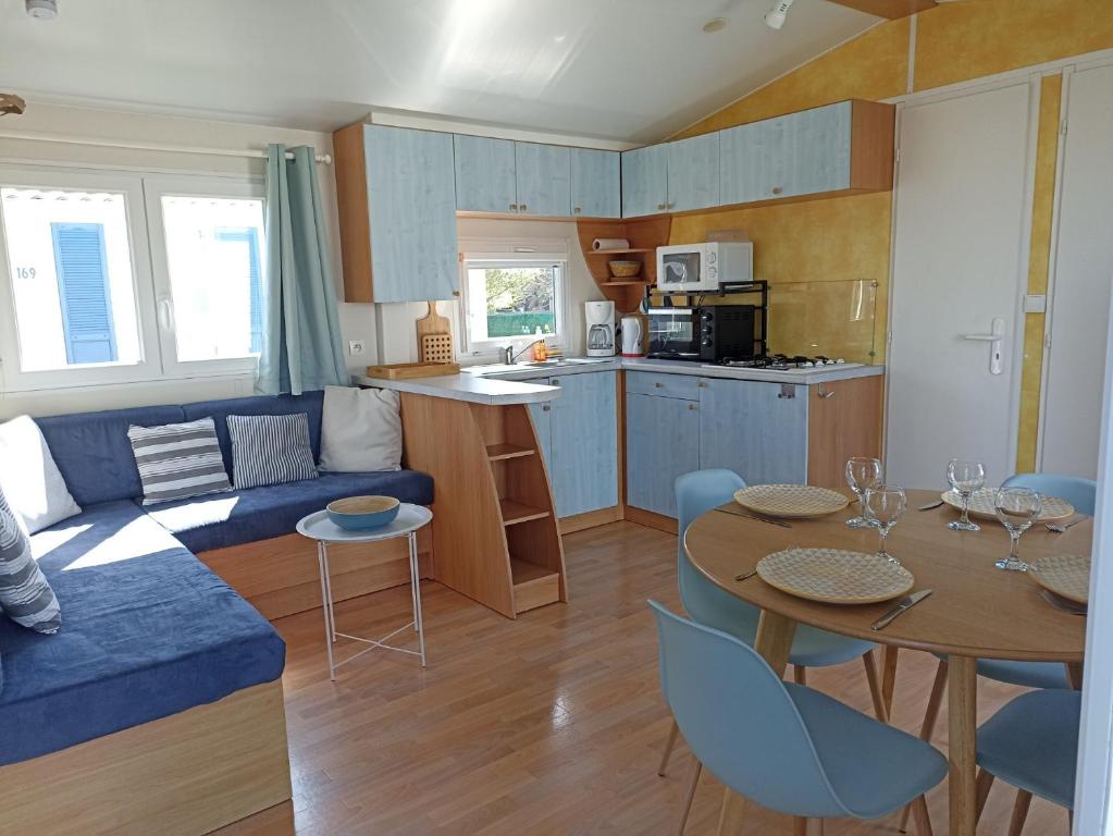 Biville-sur-MerLA CASA的客厅配有蓝色的沙发和桌子