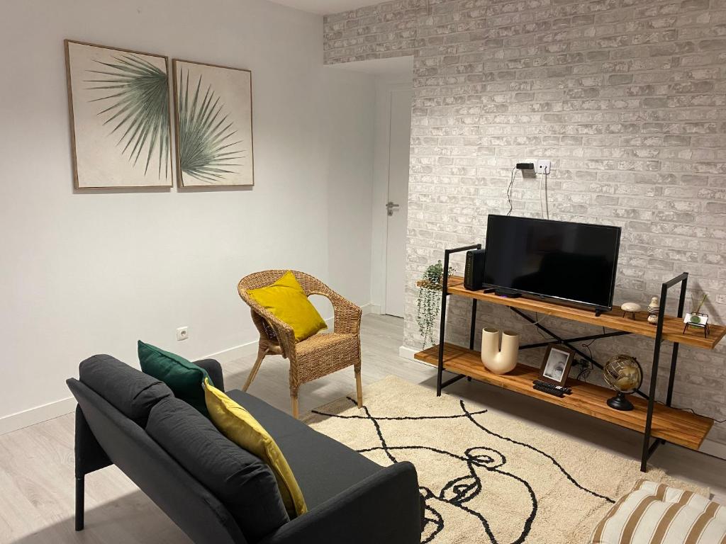 塞图巴尔5 Senses Hostel的带沙发和电视的客厅