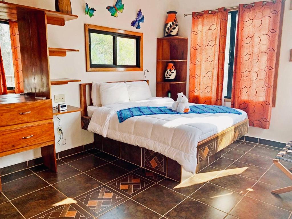 圣伊格纳西奥Mariposa Jungle Lodge的一间卧室,床上有泰迪熊