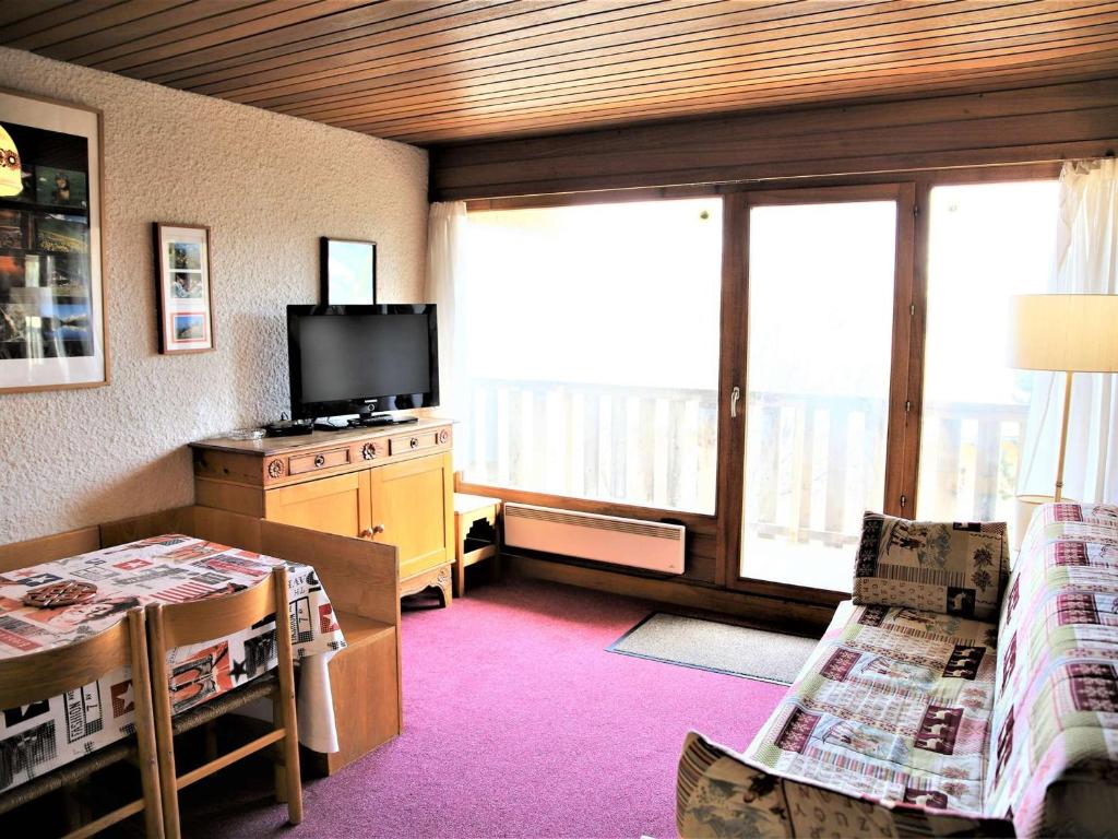 奥瑞斯Appartement Auris, 2 pièces, 4 personnes - FR-1-297-133的客厅配有电视和带桌子的桌子。