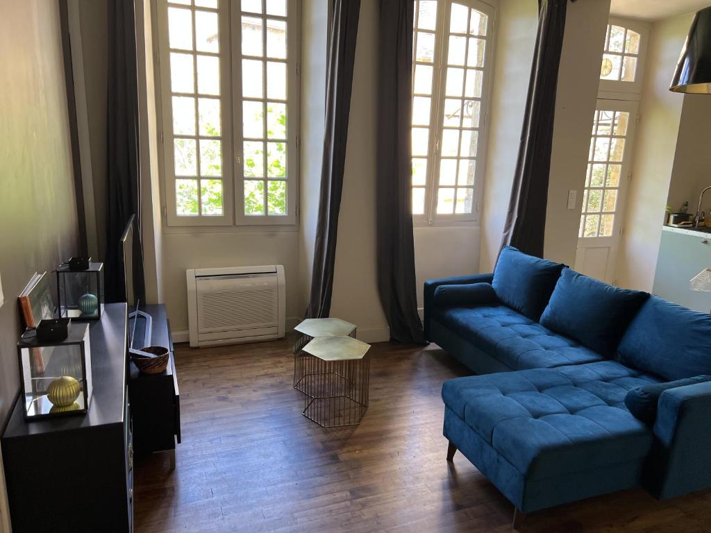 萨尔拉拉卡内达La Maison d'Albusse的客厅设有蓝色的沙发和2扇窗户。