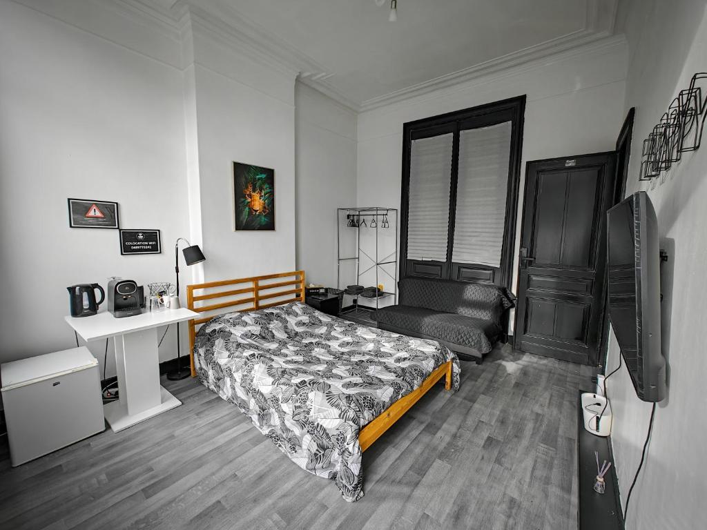 沙勒罗瓦Private Room in center of Charleroi的一间卧室配有一张床、一张书桌和一台电视