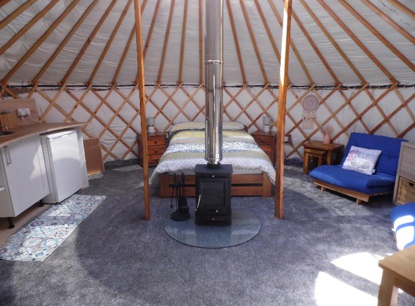 希尔代格Beinn Shieldaig Yurt的蒙古包内带一张床和炉灶的房间