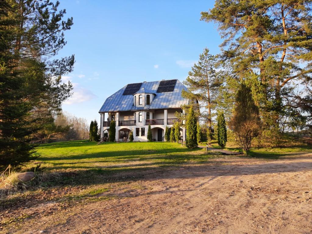 瓦尔卡Ezernieki的土路上有太阳能屋顶的房子