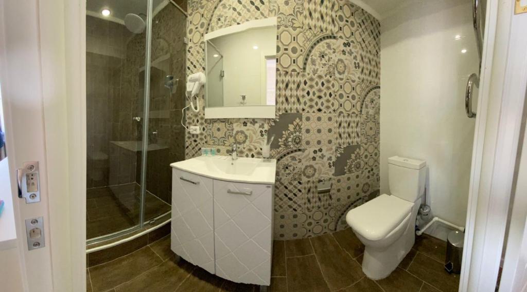 库斯塔奈De Marco Hotel的浴室配有卫生间、盥洗盆和淋浴。