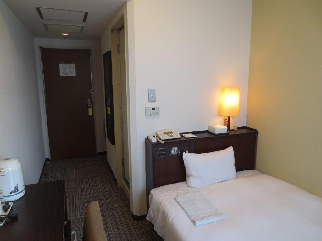 熊本熊本内斯特酒店的酒店客房,配有带灯的床铺