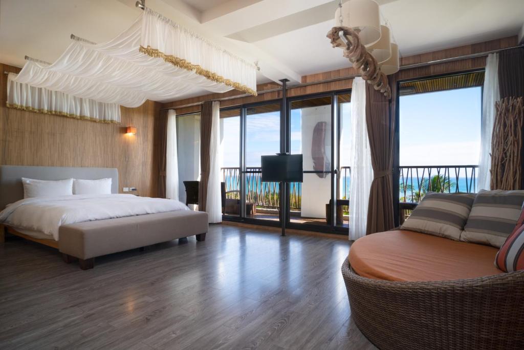 长滨乡畫日風尚會館Sinasera Resort的一间卧室配有一张床、一张沙发和窗户。