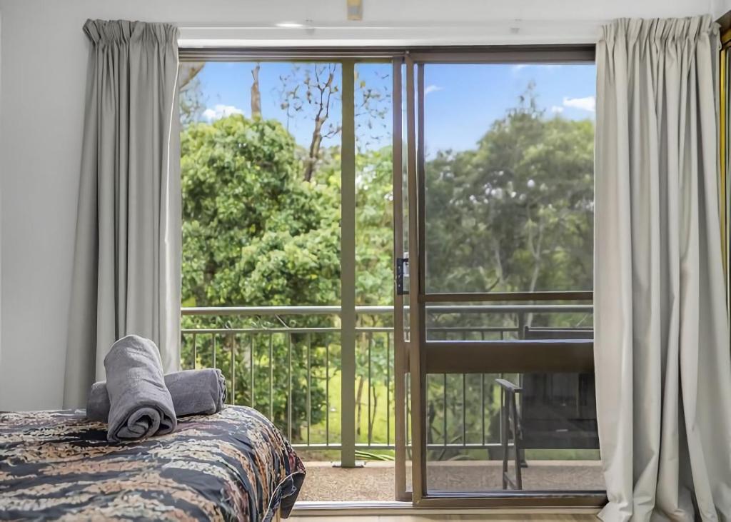 萨维特尔Banksia的一间卧室设有一张床和一个大窗户