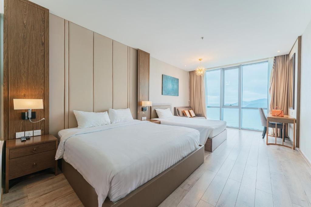 芽庄MySea Panorama Nha Trang Superview Apartments的酒店客房设有两张床和大窗户。