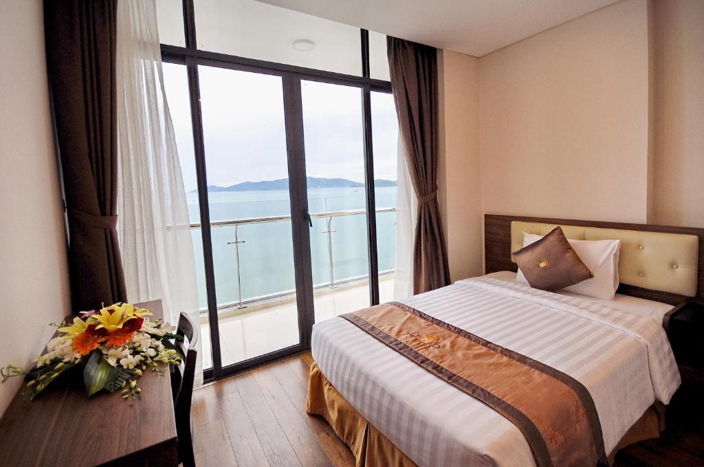 芽庄Lenid Ocean View Hotel的酒店客房设有一张床和一个大窗户