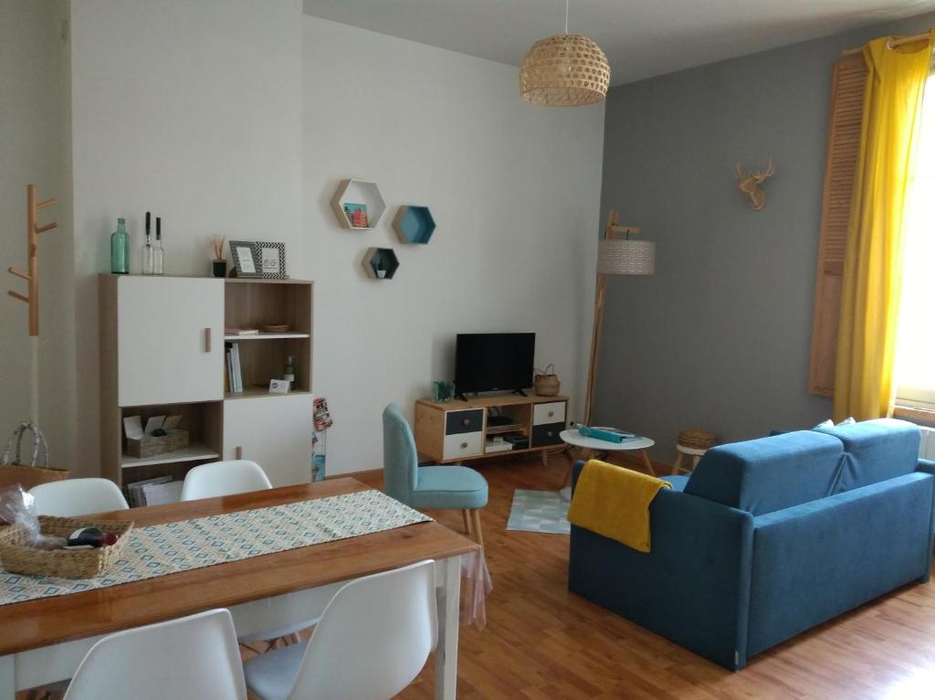 索米尔Appartement calme proche de la Loire的客厅配有蓝色的沙发和桌子