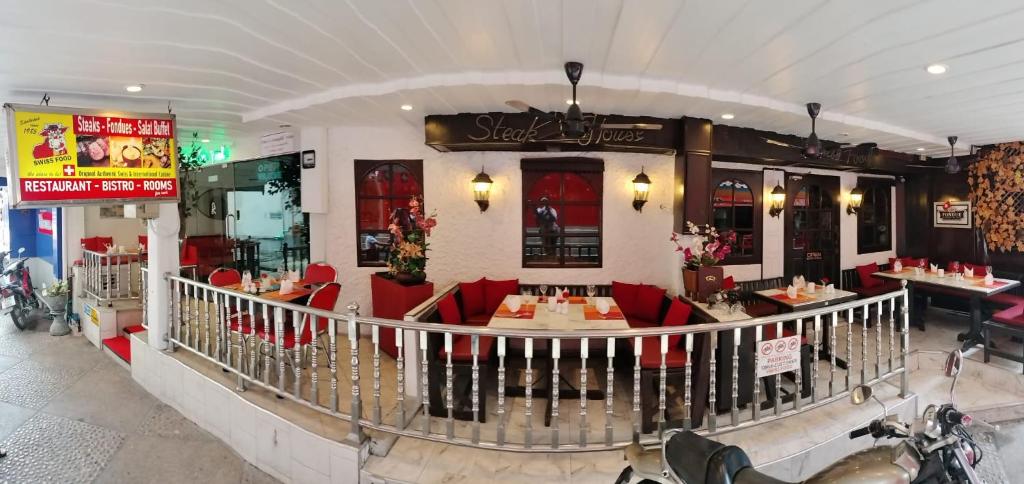 南芭堤雅Swiss Food Restaurant and room for rent的大楼内一家餐厅,配有红色的桌椅