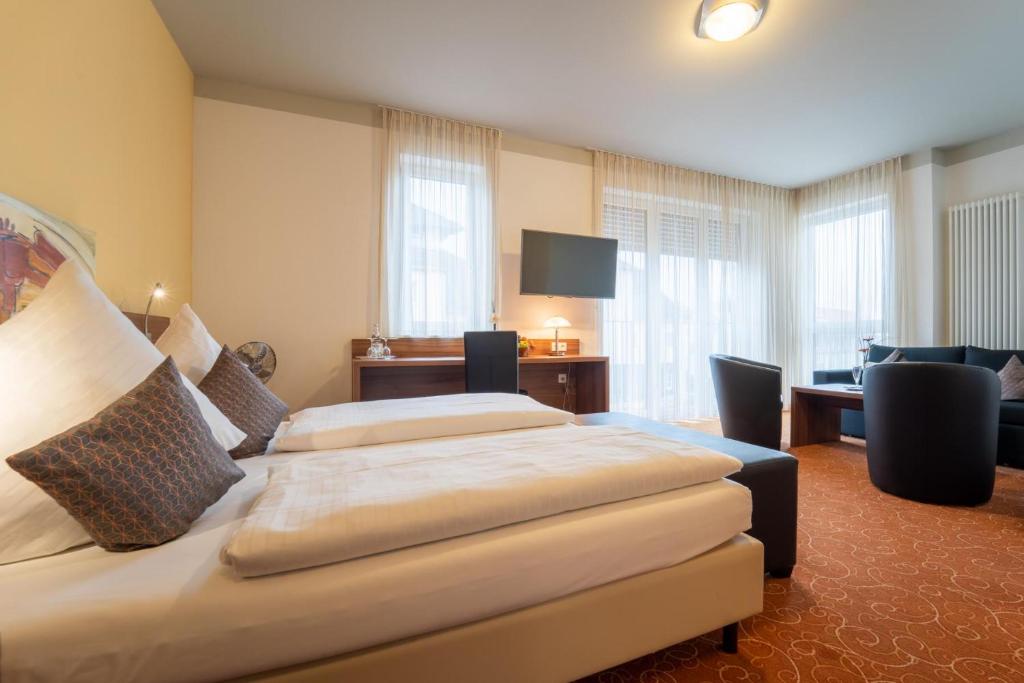 雷根斯堡Hotel St Georg - Regensburg的酒店客房配有两张床和一张书桌