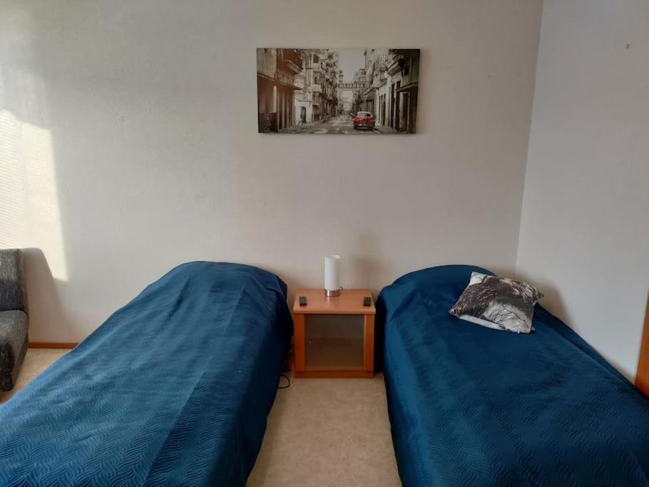 黑诺拉Toimiva kodikas yksiö的一间卧室配有两张蓝色的床和一张桌子