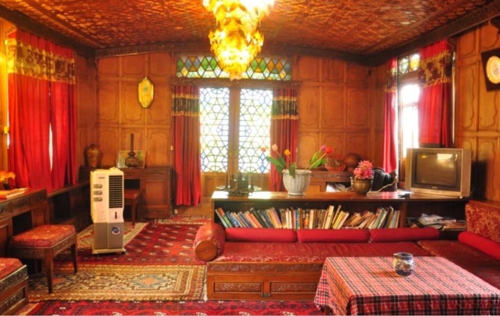 斯利那加Alif Laila Group of Houseboats, Srinagar的客厅配有红色沙发和红色窗帘