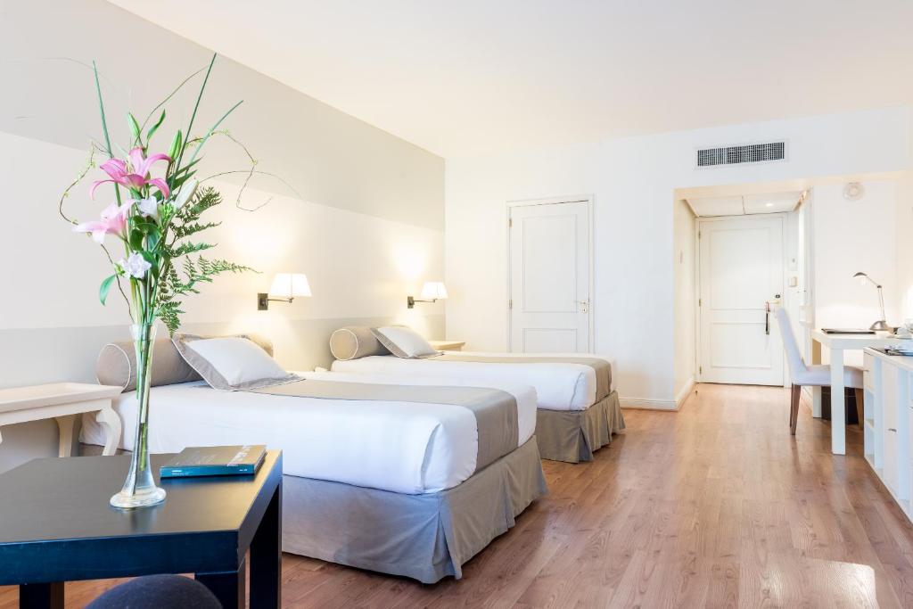 布宜诺斯艾利斯雷科莱塔套房酒店的酒店客房设有两张床和一张桌子。