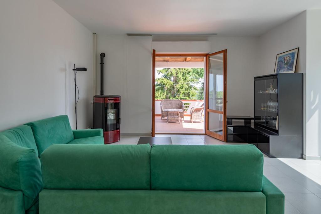 罗卡圣焦万尼La finestra sugli ulivi - YourPlace Abruzzo的客厅设有绿色沙发和滑动玻璃门