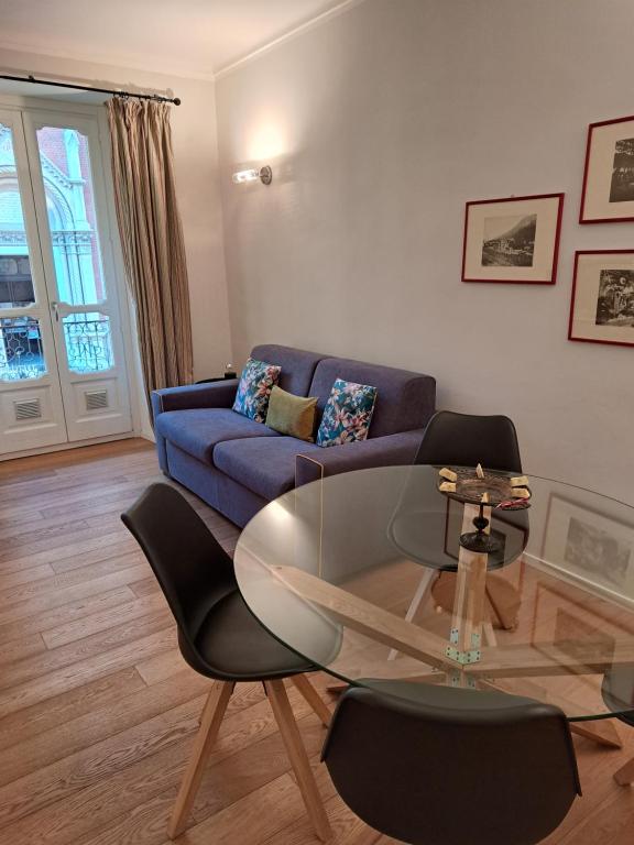 都灵Santantonio Suite, Porta Susa的客厅配有蓝色的沙发和玻璃桌