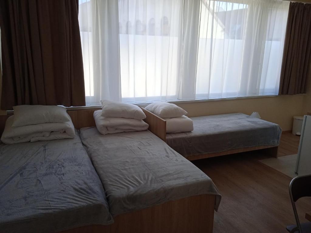 埃格尔Belvárosi Otthon Eger- Munkásszálló的酒店客房设有两张床和窗户。