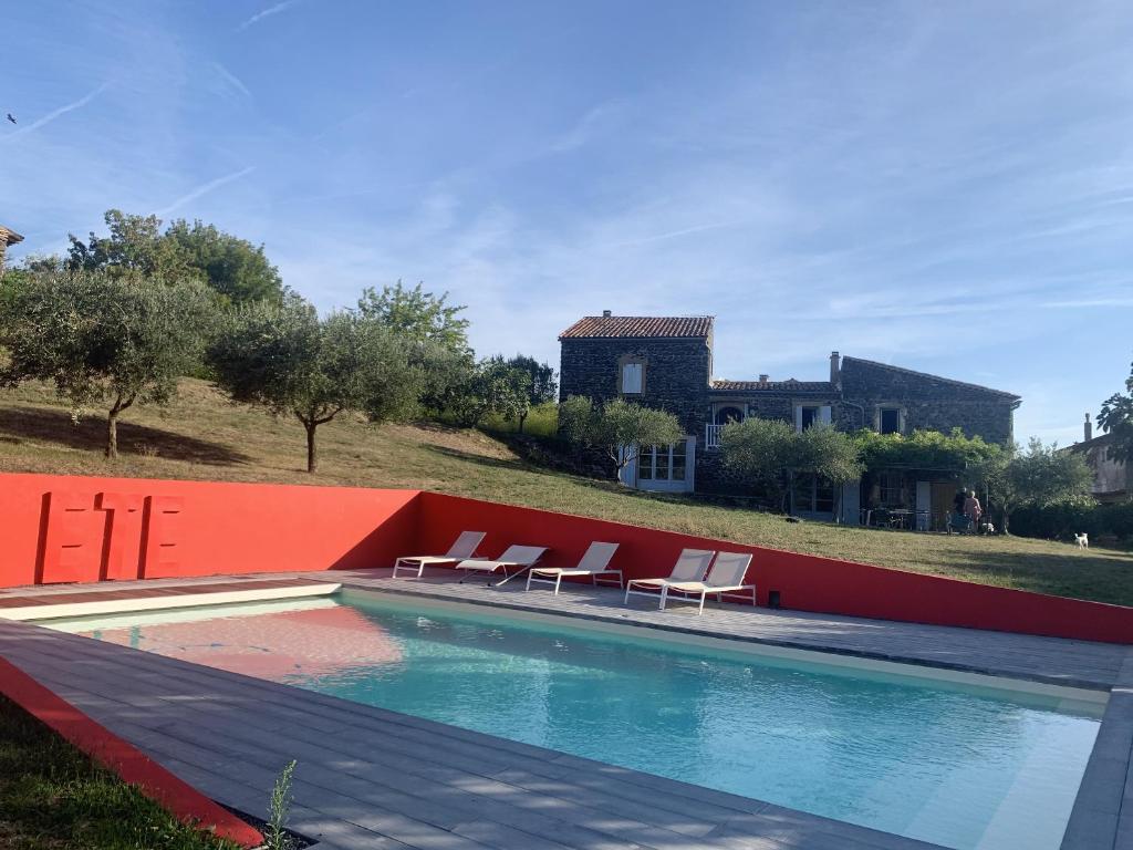 Saint-Lager-BressacMaison de 5 chambres avec piscine privee jardin clos et wifi a Saint Lager Bressac的一个带椅子的游泳池和一个背景房子