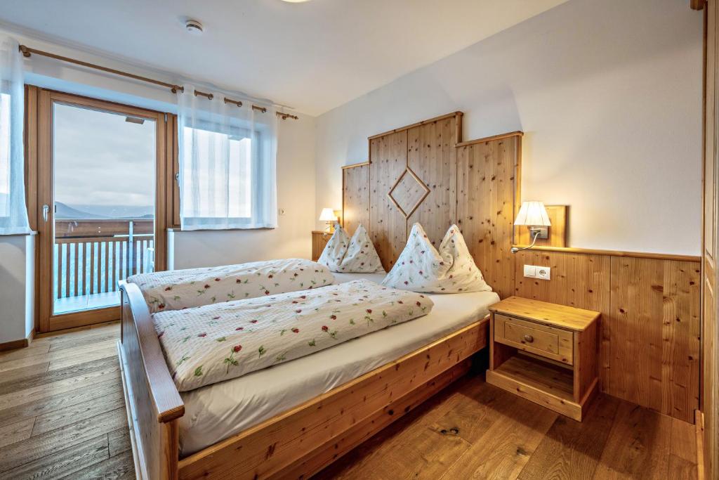 马兰扎Maurerhof Morgenrot的一间卧室配有一张带木制床头板的床和窗户。