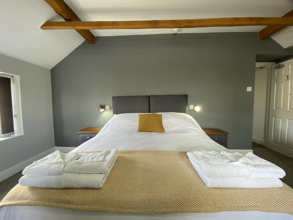 北安普敦The Roade House的一间卧室配有一张大床和两条毛巾
