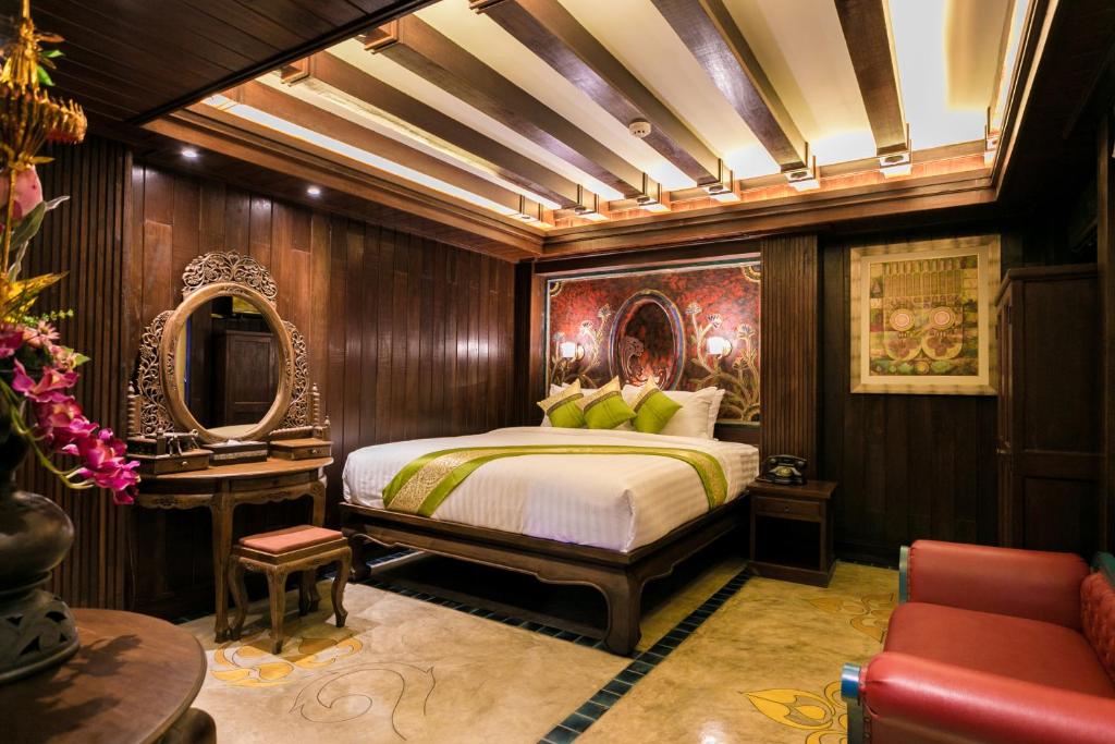 清迈南顿精品酒店的一间卧室配有一张床、一张桌子和一面镜子