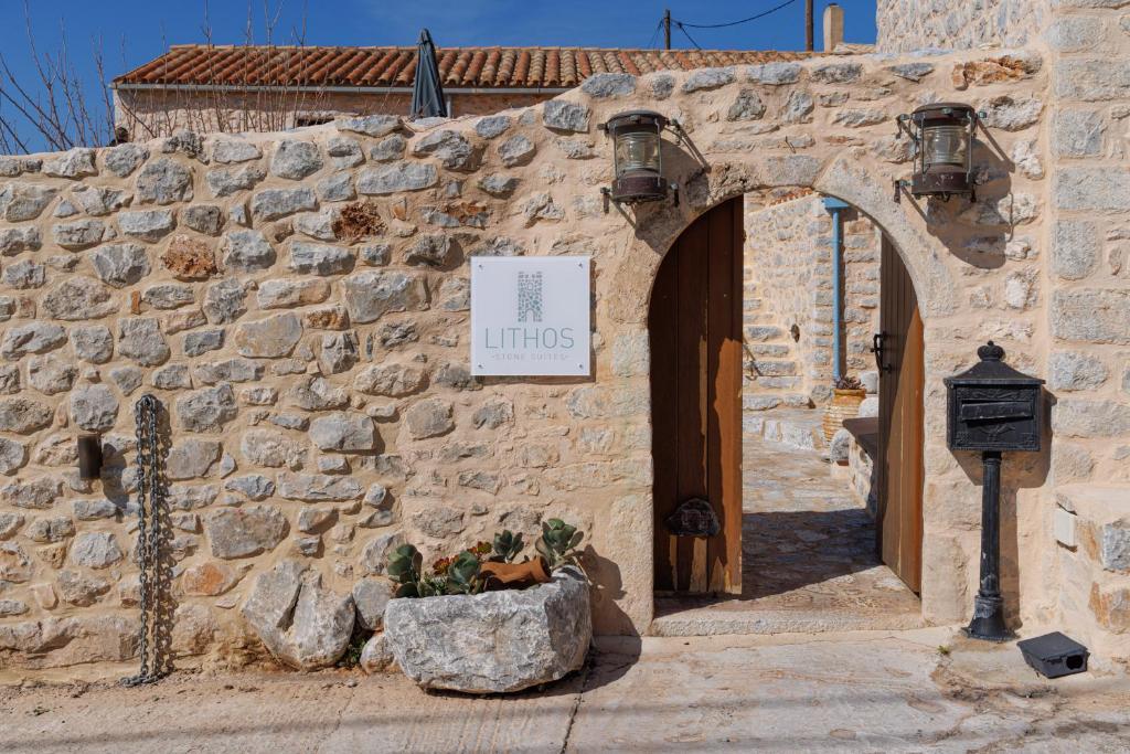 阿里奥波利斯Lithos Stone Suites的石头建筑的入口,上面有标志