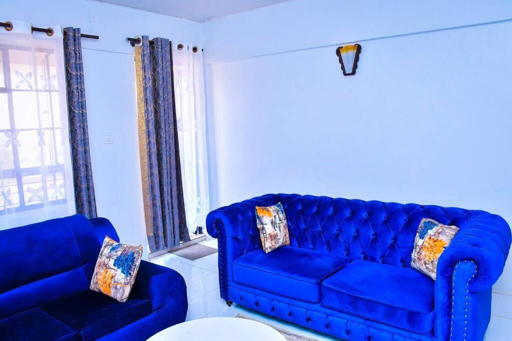 MaragoliCozier Domicile Apartments的客厅配有蓝色的沙发和椅子