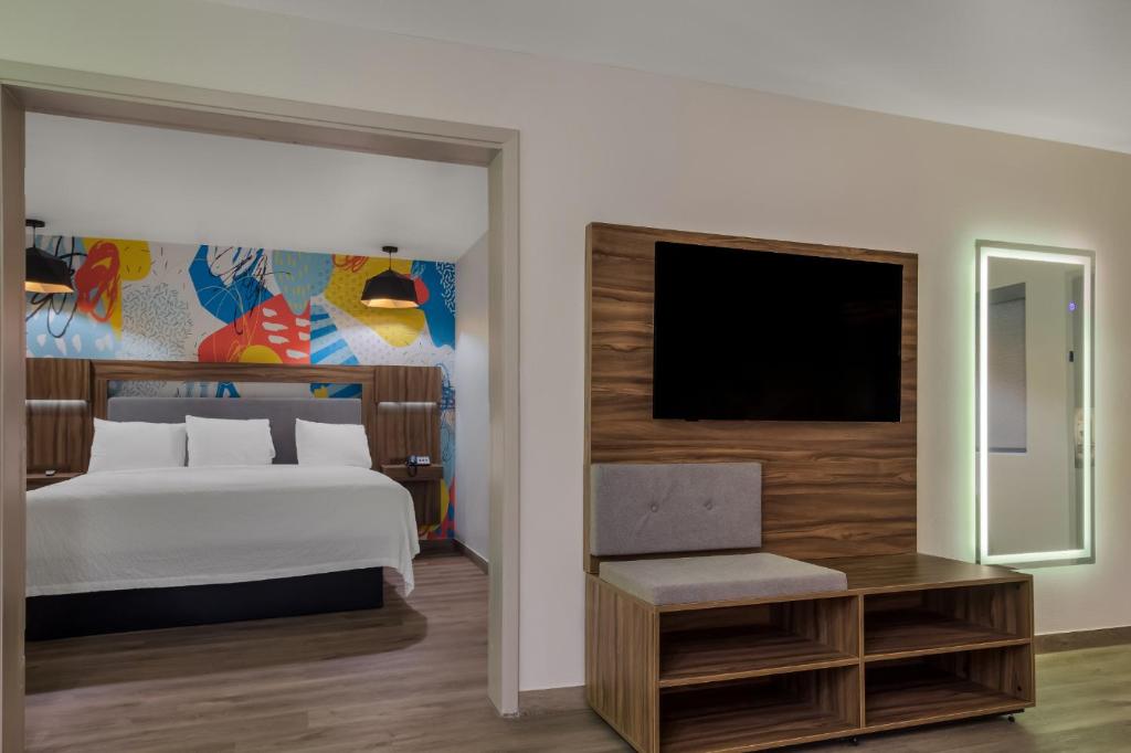 休斯顿Signature Inn Houston Galleria的一间卧室配有一张床和一台平面电视