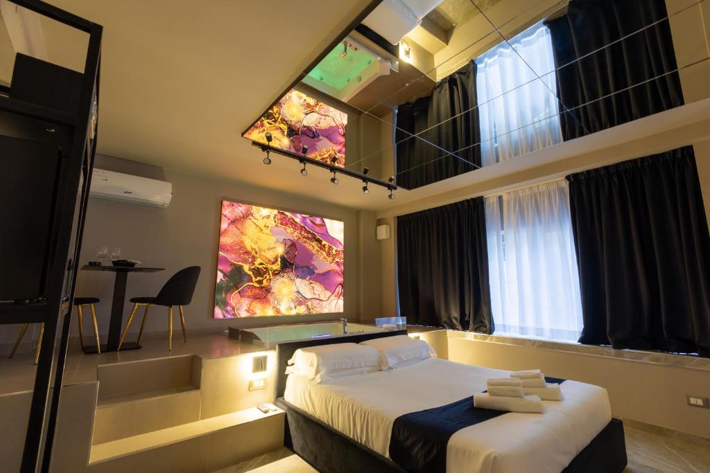 巴勒莫Maximum Exclusive Suite & Spa的一间卧室设有一张床和一个大窗户