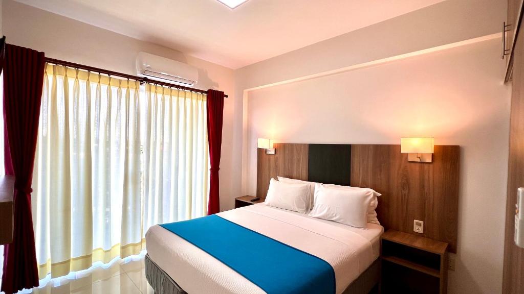 圣克鲁斯Pacifico Apart Hotel的一间卧室设有一张床和一个大窗户