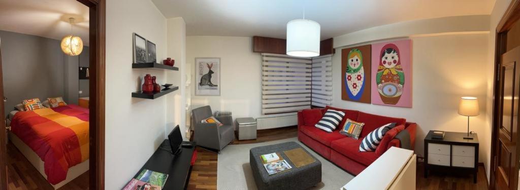 拉科鲁尼亚Apartamento zona Ria do Burgo的客厅配有红色的沙发和床。