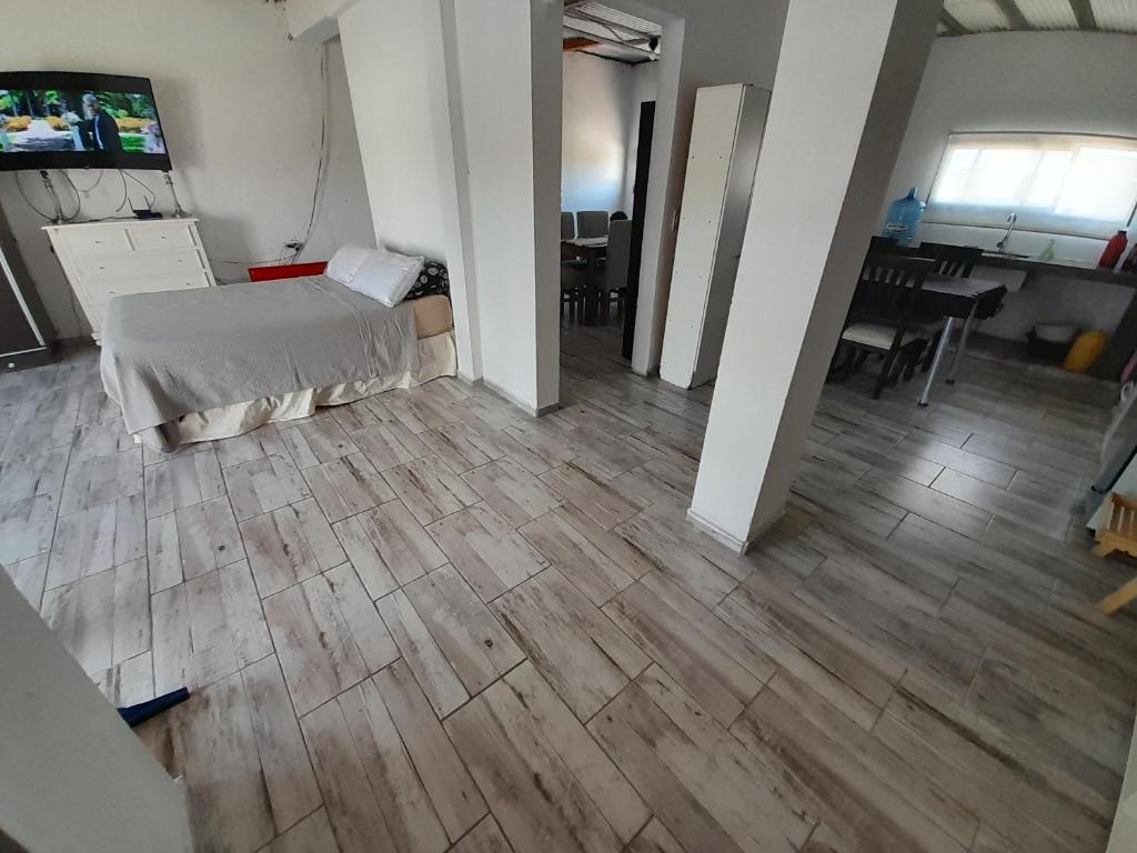 科尔多瓦Alquiler temporario villa allende的客房设有一张床,铺有木地板。