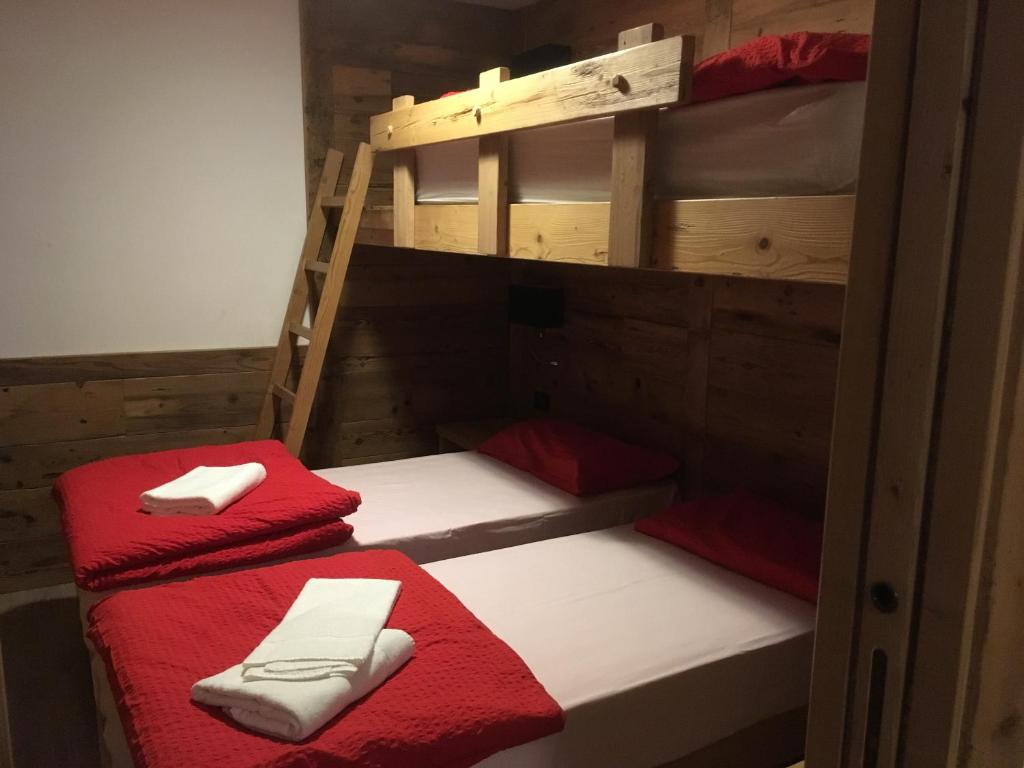 帕苏德尔托纳莱Appartamenti Miriam的两张双层床,配有红色和白色的毛巾