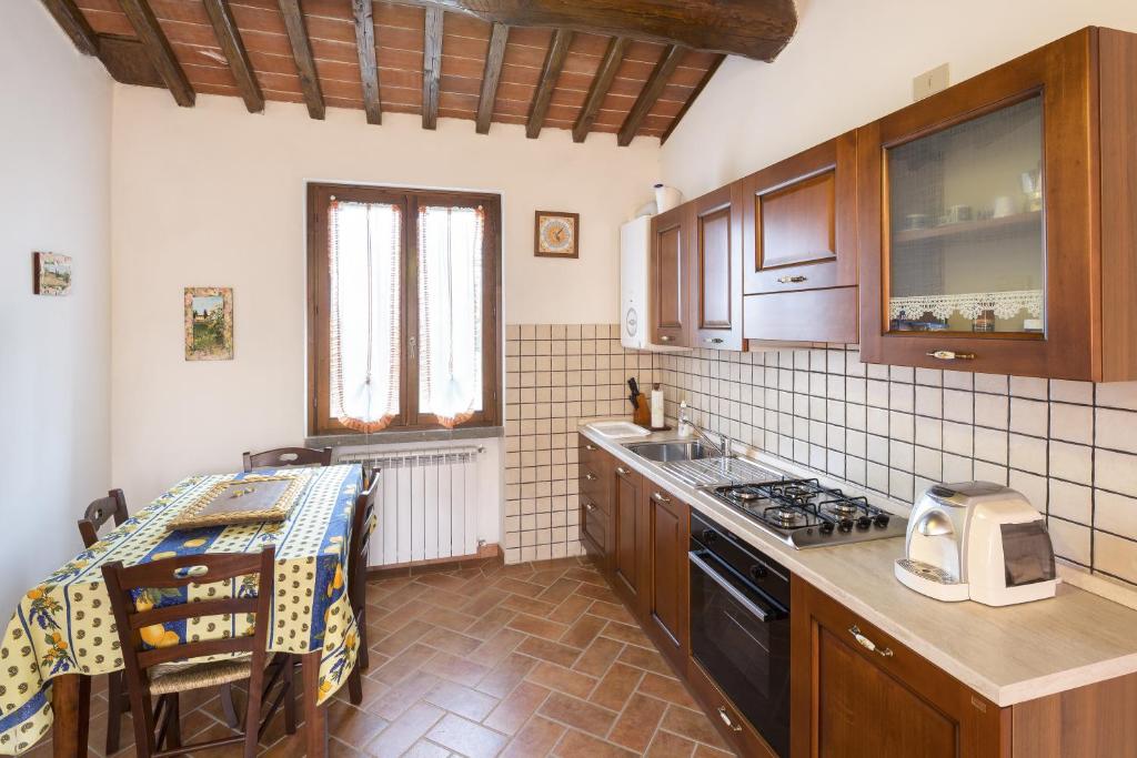 齐奇亚诺Casa Galina的厨房配有木制橱柜和炉灶烤箱。