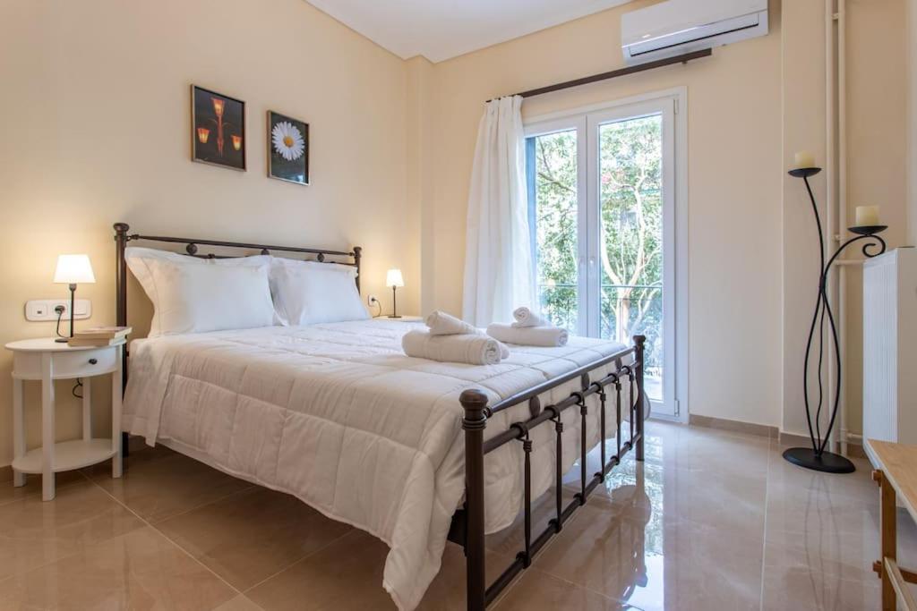 科孚镇Luxury Apartment in Garitsa Bay的一间卧室设有一张大床和一个大窗户