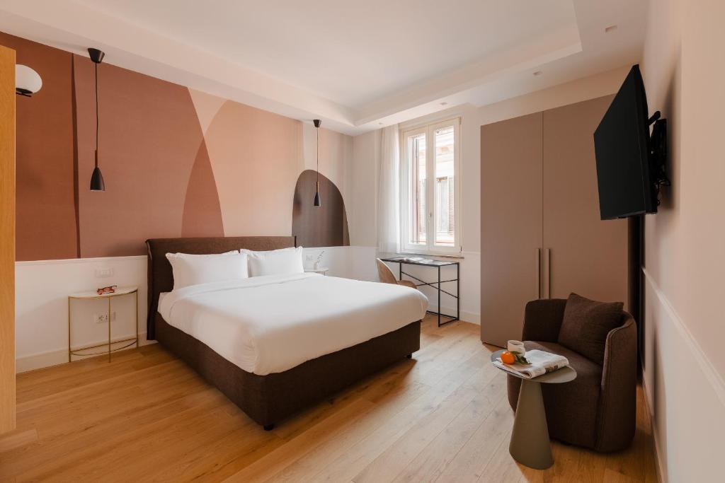 罗马Sonder Antinoo的配有一张床和一把椅子的酒店客房