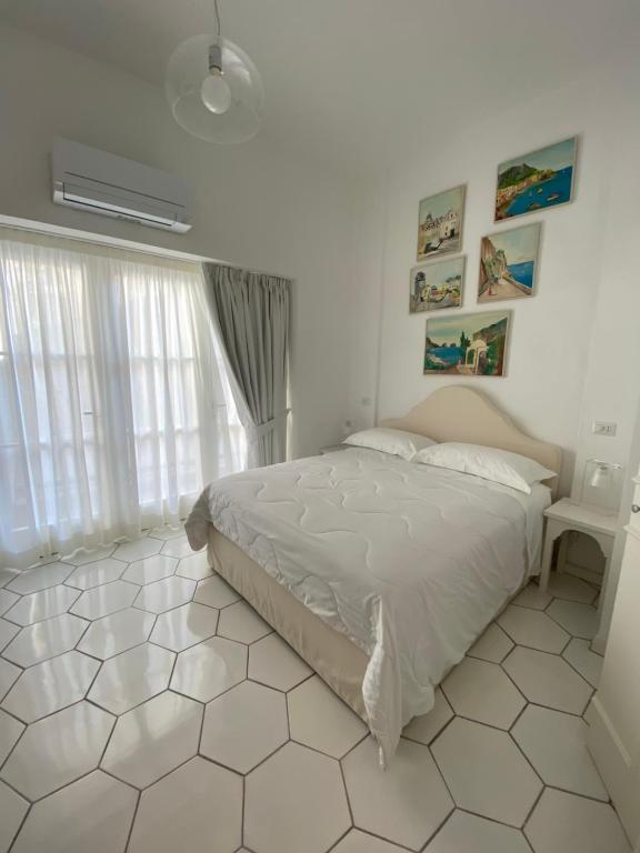 卡普里CASA ELISA的卧室配有床,铺有白色瓷砖地板。