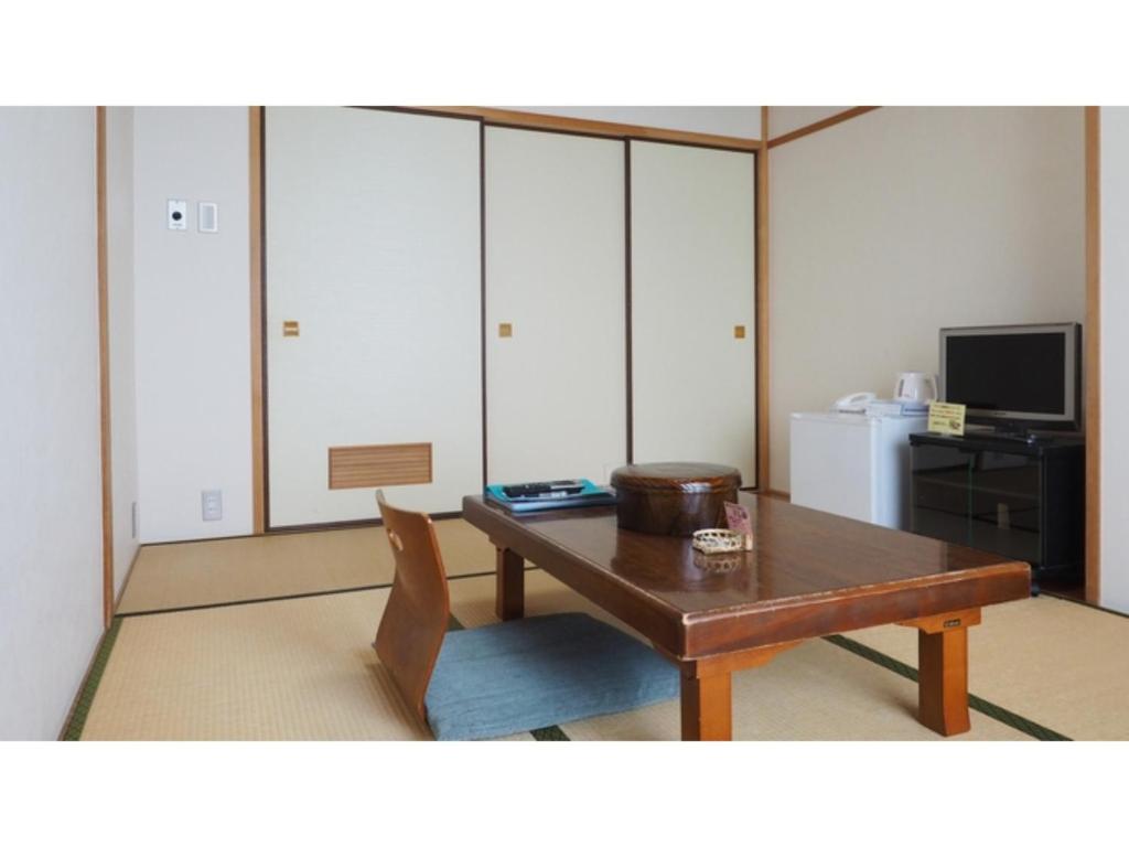 IkedaKokuminshukusha Shodoshima - Vacation STAY 59346v的客厅配有木桌和电视。