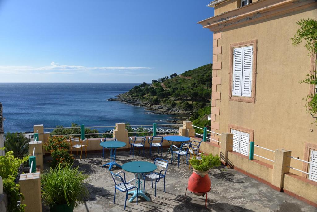 卡尼亚诺尤帕特利亚库酒店的一个带桌椅的庭院,俯瞰着大海