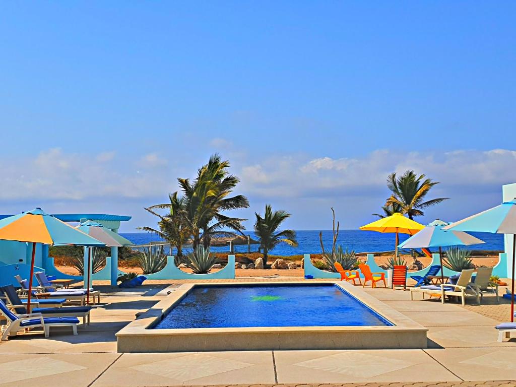 巴拉德纳维达Villa Star of the Sea的海滩上带椅子和遮阳伞的游泳池
