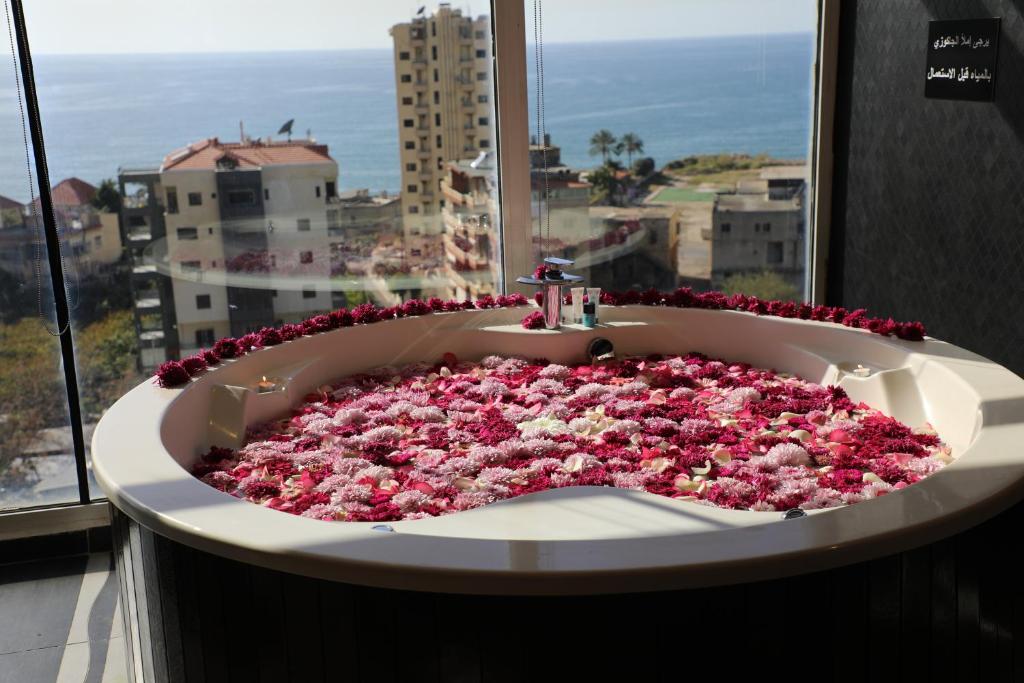 朱尼耶Dolls Hotel By Eurostars的窗户前装满鲜花的浴缸