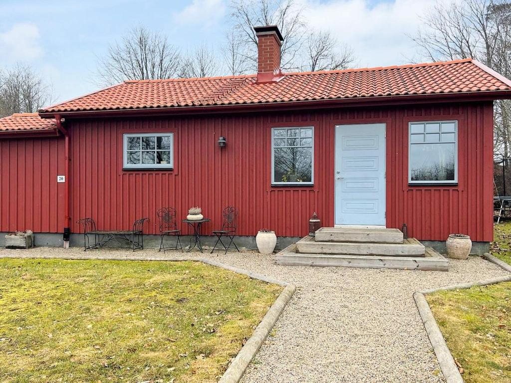 永比Holiday home LJUNGBY III的红色的房子,有红色的屋顶和白色的门