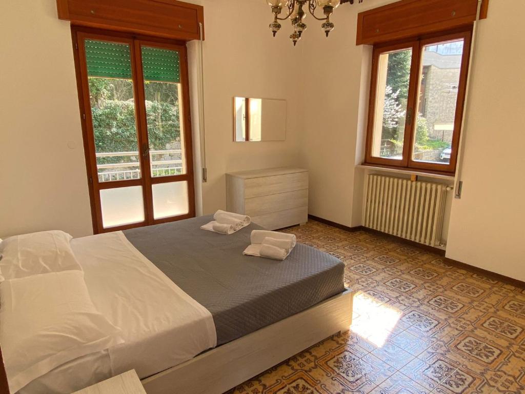圣马力诺Appartamento al Centro Storico di San Marino的一间卧室设有一张床和两个窗户。