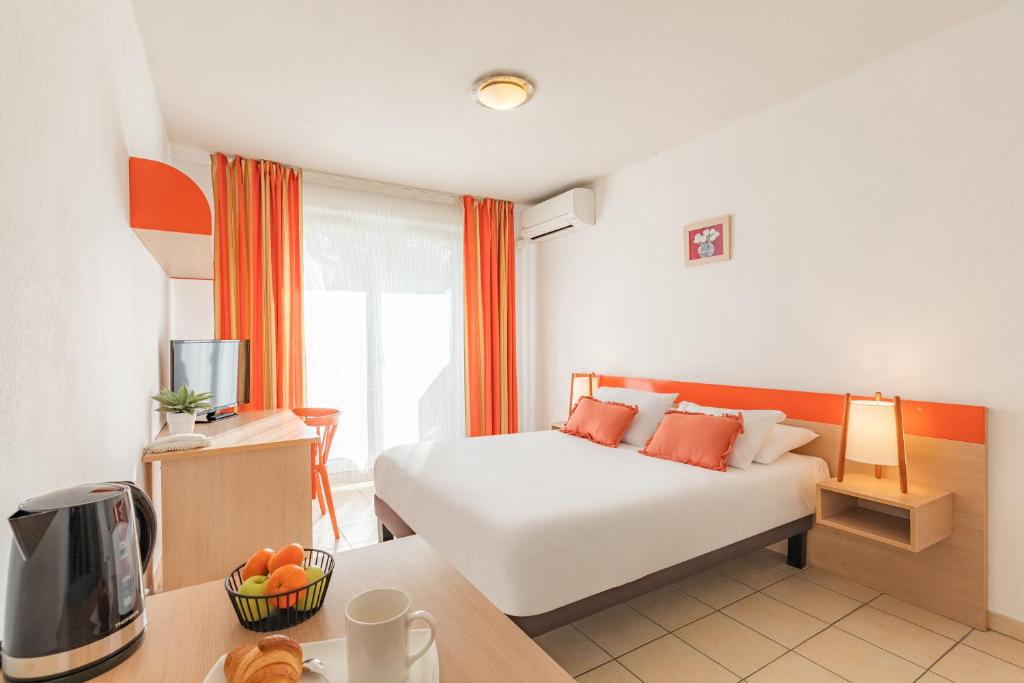 普罗旺斯艾克斯Appart'City Classic Aix-en-Provence - La Duranne的酒店客房设有一张床和一张带电视的书桌。