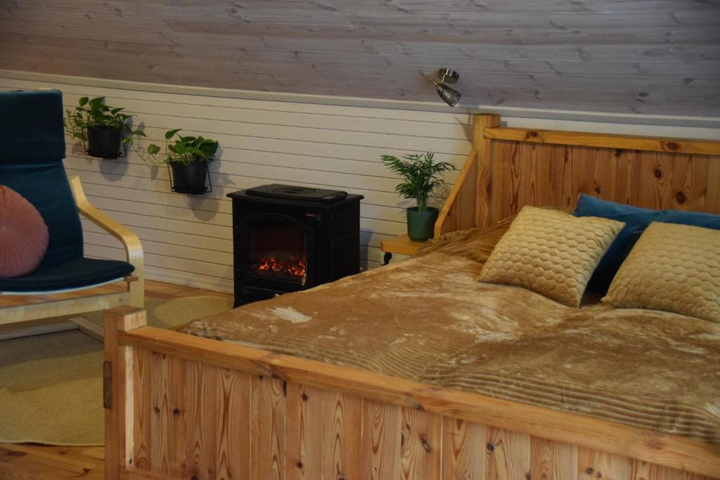 库尔迪加Čučumuiža的一间卧室配有一张床和一个燃木炉子