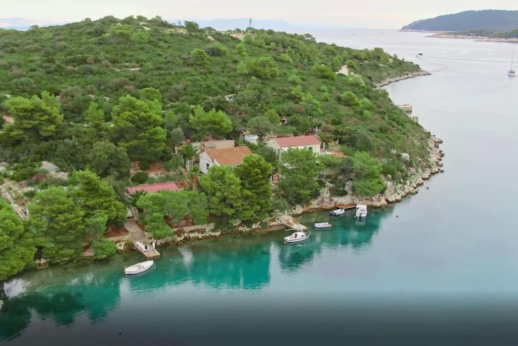 RogačićPerina Haven - Island Vis Beachfront的享有海岛的空中景色,在水中划船
